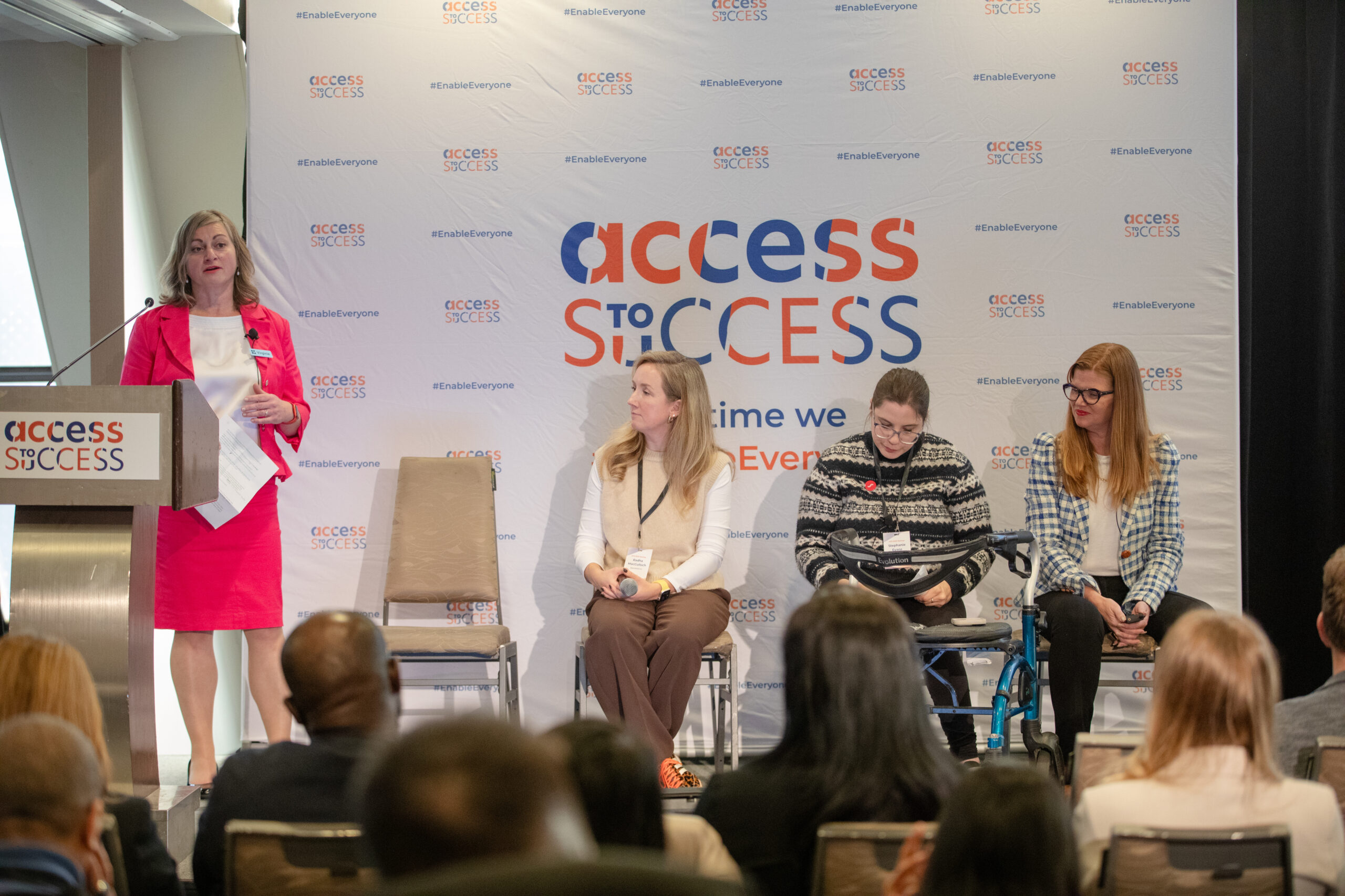 A stage and one person speaking at a podium with an Access to Success banner behind them.